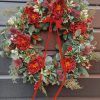 Traditional style faux Christmas wreath with red ranunculus flowers
