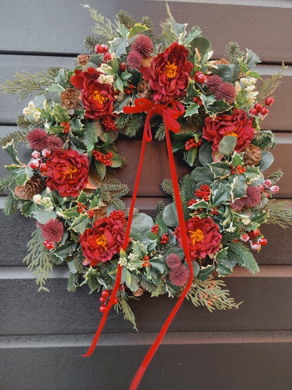 Traditional style faux Christmas wreath with red ranunculus flowers
